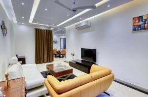 a living room with a couch and a tv at Royal escape in Gurgaon +13 photos