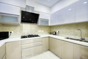 a kitchen with white cabinets and a sink at Royal escape in Gurgaon
