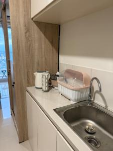 a kitchen with a sink and a counter top at Citra Plaza Nagoya City View in Kangboi