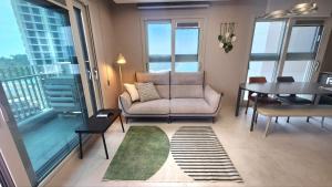 a living room with a couch and a table with a view at Busan Osiria Residence Losiria in Busan