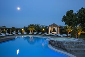 a swimming pool with lounge chairs and a gazebo at Relais Ca' Maddalena in Villafranca di Verona