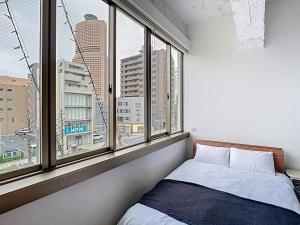 a bedroom with a bed and a large window at キュリナリーBed and Art in Hamamatsu +55 photos