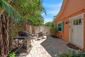 a patio with a grill and a table and chairs at Peacock Way bungalow in Holmes Beach