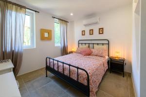 a bedroom with a bed with two night stands and two windows at Villa Giustina in Romàns dʼIsonzo +12 photos