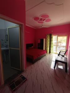 a red bedroom with a bed and a window at Welcome Home Stay & Hotel Tapovan Rishikesh in Rishīkesh