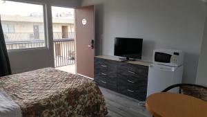 a hotel room with a bed and a tv and a room at 7 Nights Stay in Niagara Falls