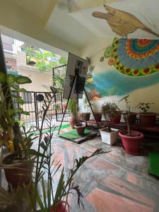 a room with potted plants and a painting on the wall at SOH Sound of Himalayas in Rishīkesh +8 photos