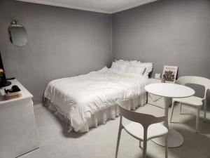 a bedroom with a bed and a table and chairs at 스테이미도 Nampo Jagalchi in Busan