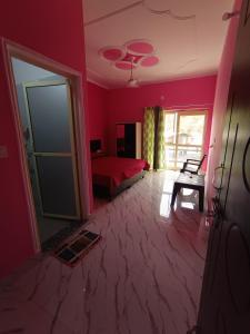 a pink room with a bed and a window at Welcome Home Stay & Hotel Tapovan Rishikesh in Rishīkesh