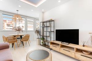 una sala de estar con un televisor y una mesa en Plazamar 044, en Torre del Mar