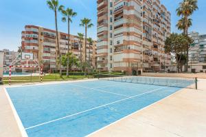 una pista de tenis frente a un edificio de apartamentos en Plazamar 044, en Torre del Mar