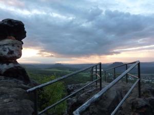 a person standing on top of a mountain looking at the sunset at Feriendomizil Elbsandsteingebirge in Königstein an der Elbe