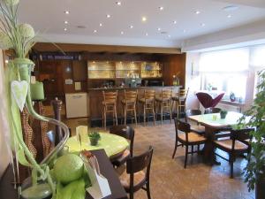 un restaurante con mesas y sillas y un bar en Hotel Rose, en Georgsmarienhütte