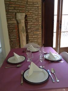 una mesa púrpura con platos y gafas sobre un mantel púrpura en Apartment Gloria, en Cáceres