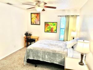 珀特奥兰治Rooms by Month Daytona的带床和吊扇的卧室