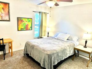 珀特奥兰治Rooms by Month Daytona的一间卧室，有一张床，两张桌子和两盏灯