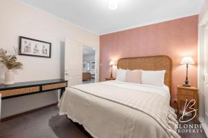 a bedroom with a large bed with white sheets at Journeyman's Cottage in Ballarat