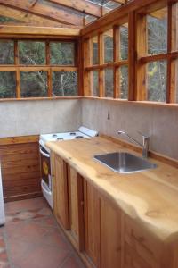 cocina con fregadero y fogones en Cabañas Lucero del Bosque en San Carlos de Bariloche