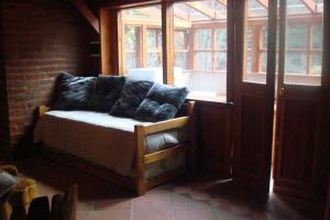 Habitación con sofá frente a una ventana en Cabañas Lucero del Bosque en San Carlos de Bariloche