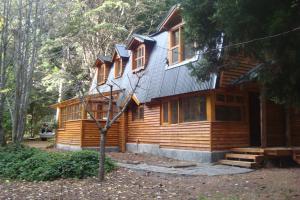 a log cabin in the woods with a tree at Cabañas Lucero del Bosque in San Carlos de Bariloche