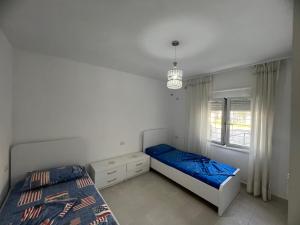 a bedroom with two beds and a window at Family Serenity Apartments in Orikum +33 photos