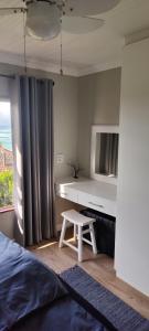 a bedroom with a desk and a bed and a table at Sandpiper 7 - Cozy Oasis in Jeffreys Bay