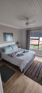 a bedroom with a bed and a large window at Sandpiper 7 - Cozy Oasis in Jeffreys Bay