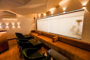 una sala de espera con un banco largo y sillas en Spree Manor Hotel, en Aurangabad