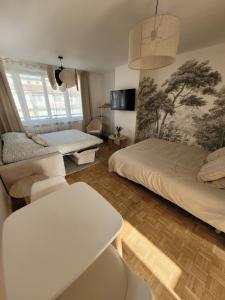 a living room with two beds and a table at Charmant studio au cœur de ville in Dunkerque