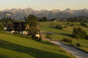 een huis op een heuvel met bergen op de achtergrond bij Złoto Jedla in Białka Tatrzanska