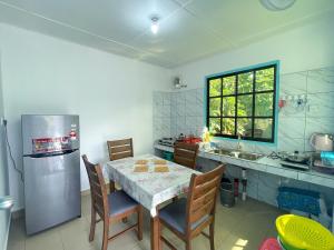 a kitchen with a table with chairs and a refrigerator at Mercy Mountain Home in Kampong Kundassan