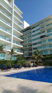 a swimming pool in front of a large building at Apartasuite Morros Vitri in Cartagena de Indias