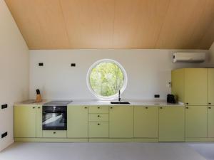 a kitchen with green cabinets and a round window at Enache's 217 in Valea lui Enache +21 photos