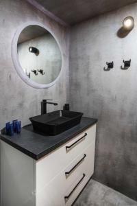 a bathroom with a black sink and a mirror at CitySoul Apartment with Balcony in Thessaloniki