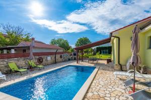 KrmedにあるVilla Roža, a beautiful villa with pool close to the beachのパティオ付きのスイミングプール、家