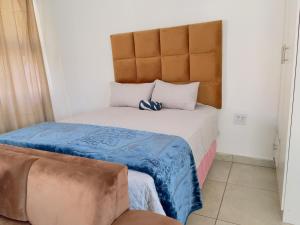 a small bedroom with a bed with a headboard at Uncle Charles guest house in Pretoria