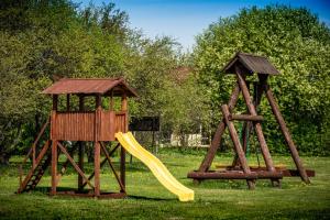 two playground equipment with a slide and a gazebo at Kempings ĒRGĻI in Bernāti