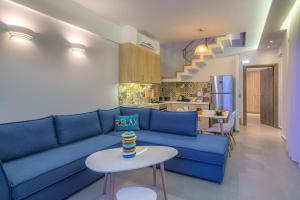 a living room with a blue couch and a table at Plakias Seaside Residences in Plakias