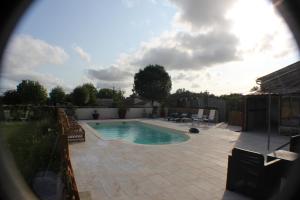a small swimming pool in a yard with a fence at Les Lilas in Saint-Savinien