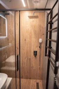 une douche avec une porte vitrée dans une salle de bain dans l'établissement Sunlit City Loft- Prime Views, à Vilnius