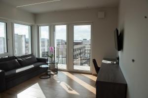 un salon avec un canapé et une grande fenêtre dans l'établissement Sunlit City Loft- Prime Views, à Vilnius