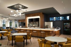 a restaurant with tables and chairs and a bar at Courtyard by Marriott Billings in Billings