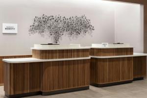 a lobby with a reception counter with a tree at Courtyard by Marriott Billings in Billings