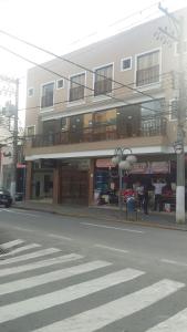 a building on a city street with a crosswalk at Vila Santa Hotel in Aparecida