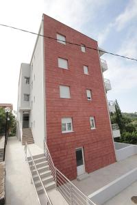 un edificio di mattoni rossi con scale di fronte di Apartments Residence Dj a Petrovac na Moru