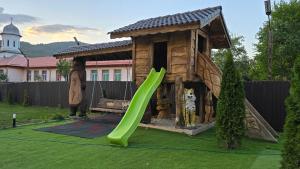a playground with a slide and a dog house at Vila Costi in Câmpina