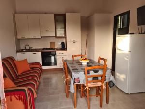 a kitchen with a table and chairs and a refrigerator at Casa il Sole Casevacanze Ferienwohnung Daniele Furco in Castellammare del Golfo