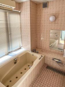 a bathroom with a tub and a shower and a window at 渡边ビル201 in Tokyo +4 photos