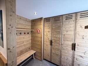 a room with wooden lockers and a bench in it at Résidence Domaine Du Loup Blanc - Appartement de standing pour 8 personnes MAE-4514 in Les Orres