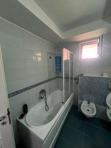 Un baño blanco con bañera y inodoro. en Apartament Flammarion, en Oradea 4 fotos más